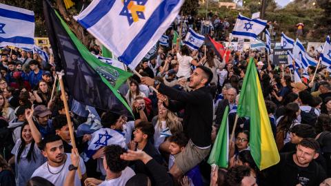 Demonstrators hold military and Israeli flags during a protest in front of the Knesset (Israeli parliament) in Jerusalem on April 2, 2025, calling for the goverment to enforce the mandatory military service to all people, including ultra-Orthodox Jewish men. (Photo by Menahem KAHANA / AFP) (Photo by MENAHEM KAHANA/AFP via Getty Images)