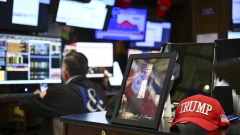 A photograph of President Donald Trump sits on a desk as traders work on the floor of the New York Stock Exchange at the opening bell on April 8, 2025, in New York City. (Getty Images)