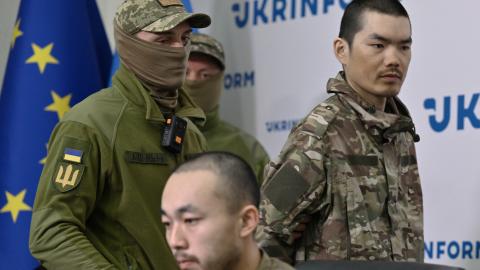 A serviceman of Security Service of Ukraine escorts Chinese prisoner of war in Kyiv on April 14, 2025, amid the Russian invasion of Ukraine. (Genya Savilov/AFP via Getty Images)