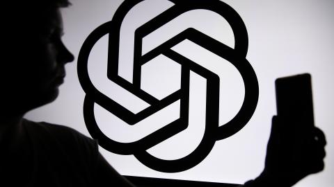 The ChatGPT logo appears with a person in front of it. (Klaudia Radecka via Getty Images)