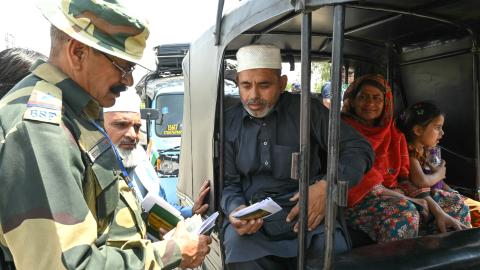 An Indian Border Security Force soldier checks the passports of Pakistani citizens as they return to their country at the India-Pakistan border on the outskirts of Amritsar, India, on April 25, 2025. (Narinder Nanu via Getty Images)