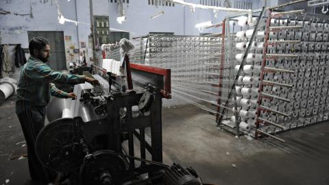 A Pakistani man prepares threads at a textile factory in Gujrat, on April 9, 2009. ( Farooq Naem /AFP via Getty Images)