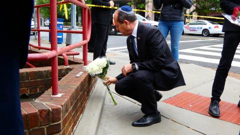 Minister of Economy of Israel Nir Barkat lays flowers at the cordoned-off crime scene in Washington, DC, on May 22, 2025. (Luzia Geier/picture alliance via Getty Images)