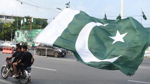 People hold a Pakistani national flag on a motorbike to celebrate the country's Independence Day in Lahore, Pakistan, on Aug. 14, 2022. (Sajjad/Xinhua via Getty Images)