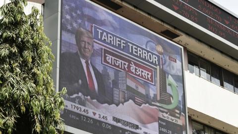 A broadcast screen at the Bombay Stock Exchange in Mumbai, India, on April 3, 2025, displays news of US President Donald Trump announcing sweeping new trade tariffs. (Indranil Aditya via Getty Images)