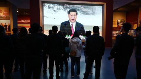 People walk past a video screen showing a speech by Chinese President Xi Jinping at the Museum of the Communist Party of China in Beijing on March 3, 2023. (Greg Baker via Getty Images)