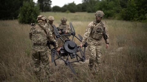 Ukrainian soldiers calibrate an agricultural drone, transformed into a front-line delivery system, during a demonstration at an undisclosed location near Dnipropetrovsk, Ukraine, on June 14, 2025. (Florent Vergnes via Getty Images)