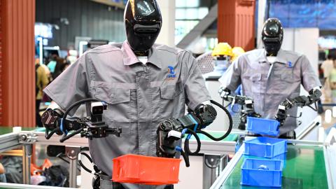 Qinglong humanoid robots sort goods at a logistics sorting line during the 2025 World Artificial Intelligence Conference at the Shanghai World Expo Exhibition and Convention Center on July 26, 2025. (Tian Yuhao via Getty Images)
