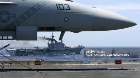 India's lone aircraft carrier, the INS Viraat sails alongside a US fighter plane on the US super-carrier Kitty Hawk in the Bay of Bengal, during the Malabar exercise, 07 September 2007. Twenty-seven ships and submarines from the United States, Australia, Japan and Singapore have joined seven from host India off the Andamans archipelago in the Bay of Bengal for six-day manoeuvres in the international exercises, codenamed Malabar, which started on the 04 September. AFP PHOTO/Deshakalyan CHOWDHURY (Photo credi