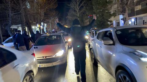 A protester flashes victory signs as traffic slows during demonstrations in Hamedan, Iran, on January 1, 2026. The demonstrations erupted after shopkeepers in Tehran’s Grand Bazaar shut their businesses to protest the sharp fall of Iran’s currency and worsening economic conditions. (Getty Images)
