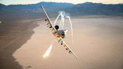 An A-10 Thunderbolt II assigned to the 66th Weapons Squadron, out of Nellis Air Force Base, deploys defensive flares during an evasive maneuver over a training range while escorting a C-130H assigned to the 152nd Airlift Wing, Nevada Air National Guard, Nevada, Feb. 26, 2026. The Flares are used to counter heat-seeking threats by diverting incoming missiles away from the aircraft. (U.S. Air Force photo by Tech. Sgt. Albert Valladares)