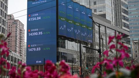 A screen showing the Shanghai composite index, Shenzhen component index, and Beijing stock exchange 50 index is seen in the Jing'an district of Shanghai on March 2, 2026. (Getty Images)