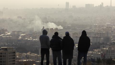 Men watch from a hillside as a plume of smoke rises after an explosion on March 2, 2026, in Tehran, Iran. (Getty Images)