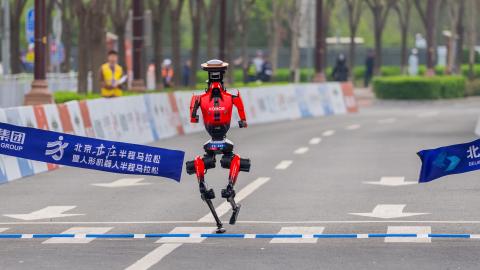 : Honor's "Lightning" humanoid robot from team Qitian Dasheng (Great Sage) crosses the finish line during the Beijing humanoid robot half marathon, on April 19, 2026 in Beijing, China. Completing the race with a net time of 50 minutes and 26 seconds, the champion robot showcased an impressive performance, beating the human half marathon record of 57 minutes and 20 seconds. (Photo by VCG/VCG via Getty Images)