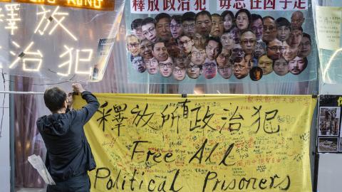  pro-democracy activist hangs a yellow banner with the message "Free All Political Prisoners" during a protest in Hong Kong. Pro-democracy activist Koo Sze-yiu stages a protest in Hong Kong, against the National Security Law (NSL) and demanding the release of all the political prisoners in Hong Kong. (Photo by Miguel Candela/SOPA Images/LightRocket via Getty Images)