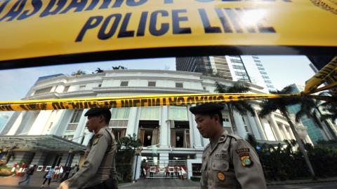 Policemen walk past the Ritz-Carlton hotel in Jakarta on July 20, 2009, after a blast tore through the hotel. (Getty Images)