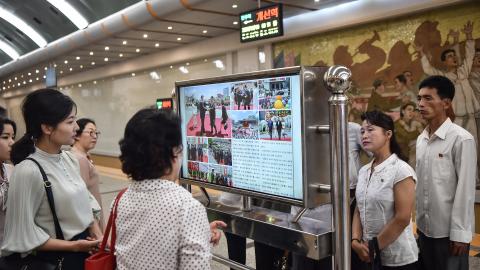 Commuters in the Kaeson Station of the Pyongyang Metro look at a screen with the newspaper “Rodongsinmun” showing news about Xi Jinping’s visit to North Korea on June 9, 2026. (Getty Images)