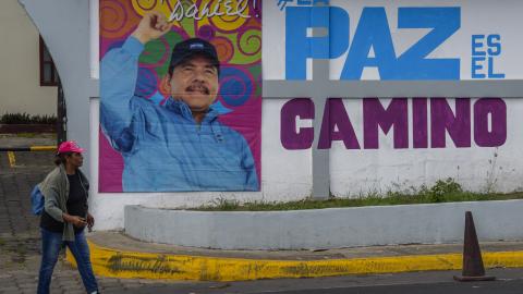 A woman walks in front of a billboard with a picture of Nicaraguan President Daniel Ortega at the Ministry of Family Economy on June 27, 2021, in Managua, Nicaragua. (Getty Images) Share to Twitter