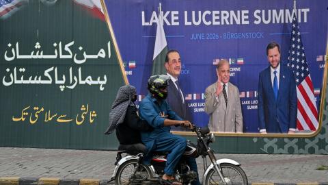 A family rides past a billboard featuring Pakistan’s Prime Minister Shehbaz Sharif, Pakistan’s Chief of Army Staff Field Marshal Asim Munir, and US Vice President JD Vance at the Lake Lucerne summit in Switzerland on July 7, 2026. (Getty Images)