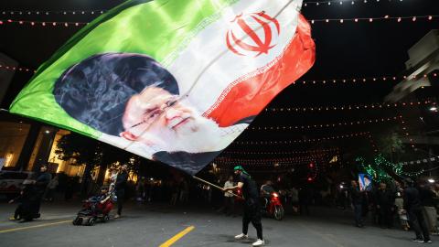 A man waves a flag near Imam Reza’s shrine in Mashhad, Iran, on July 9, 2026. (Getty Images)