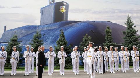 Vladimir Putin attends a ceremony to mark Navy Day at the Main Admiralty in Saint Petersburg on July 26, 2026, in front of a large photo of a submarine. (Getty Images)