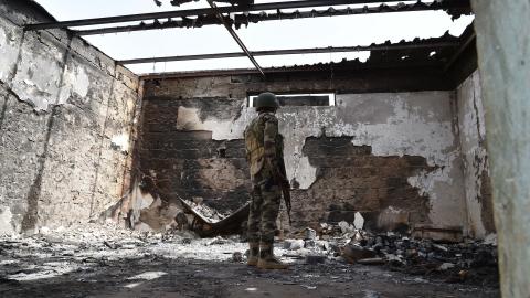 A soldier stands at a damaged house in Bosso military camp on June 17, 2016, following attacks by Boko Haram fighters. (Getty Images)