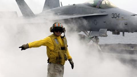 A sailor prepares to launch an F/A-18C Hornet off the flight deck of the USS Kitty Hawk in the Philippine Sea on May 6, 2008. (US Navy)