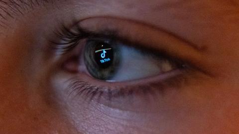The TikTok social media platform's logo is reflected in the eye of a 13-year-old boy as he looks at a computer screen on November 25, 2023, in Bath, England. (Getty Images) Share to Twitter