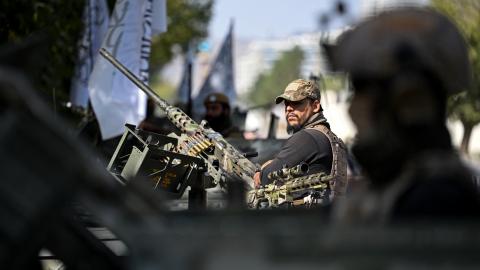 Taliban security personnel stand guard atop armored Humvees along a road in the Green Zone area in Kabul on August 12, 2026. (Getty Images)
