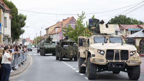 Military vehicles from the US Army, British Army’s Light Dragoons, and Romanian Armed Forces—which are all part of the NATO Forward Land Forces Battle Group-Poland—maneuver during a Polish Armed Forces Day parade in Orzysz, Poland, on August 16, 2026. (US Army Reserve)