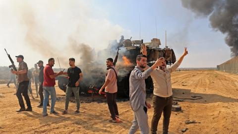 Palestinians take control of an Israeli Merkava battle tank after crossing the border fence with Israel from Khan Yunis in the southern Gaza Strip on October 7, 2023. (Getty Images)