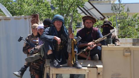 Armed Taliban security personnel sit on a humvee armoured vehicle outside a mosque in Argo district, Badakhshan province on May 6, 2024. From satellite images, Afghanistan's Taliban rulers have seen success in slashing opium production, but on the ground, farmers stripped of their livelihoods have resisted anti-narcotics units -- sometimes at the cost of their lives.The end of last week was marked by violent clashes in mountainous Badakhshan province that left two dead, according to provincial police (Photo