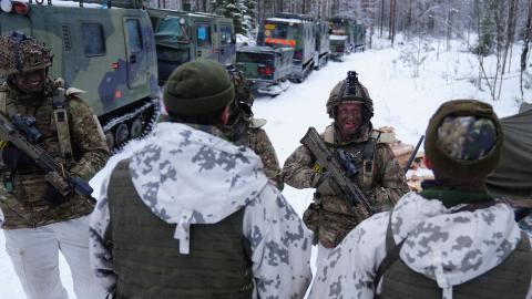 A British corporal talks with Finnish soldiers at Vuosanka near Kajaani, Finland, during NATO’s Northern Axe exercise along the Russian border. (Getty Images)