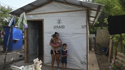 A mother with her children, outside a shack she built with the help of USAID on the banks of the Ulua River in Honduras on July 15, 2022. (Getty Images)
