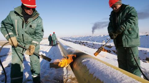 Kazakh oil workers lay an oil pipeline by the Canadian oil company Hurricane Kumkol Munai on December 19, 2002, north of Kyzylorda, Kazakhstan. (Getty Images)