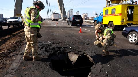 Police officers look at the damages following a Russian drone strike on the Northern Bridge in Kyiv on October 4, 2026, amid the Russian invasion of Ukraine. Russia struck another major bridge in Kyiv on October 4, soon after Germany's chancellor arrived on a surprise visit to show European support in the face of an upsurge in attacks. (Photo by Mykola TYMCHENKO / AFP via Getty Images)