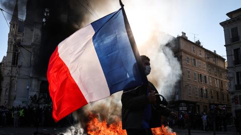 A protester walks past a fire during clashes prior to the start of a protest in Marseille, France, on October 17, 2026. (Getty Images)