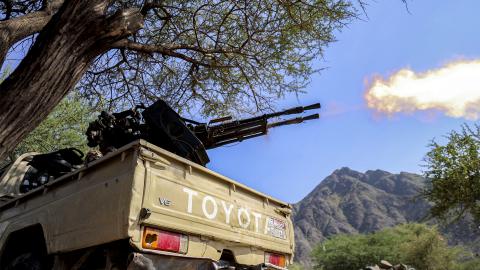 A fighter loyal to Yemen's internationally-recognised government fires a turret from the back of a pickup truck at a position along the frontlines against the Houthis around Mount al-Midan in Yemen's western Taiz province on October 26, 2026. The Saudi-led coalition fighting the Houthis has launched hundreds of raids in Yemen backing the internationally recognised government since the start of the renewed fighting in the long-running civil war. The conflict, dormant for years, erupted again in July and inte