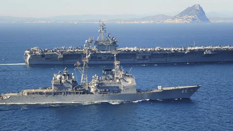 USS Vicksburg escorts the Nimitz-class aircraft carrier USS Theodore Roosevelt by the Rock of Gibraltar, March 31, 2015 (Anthony Hopkins II/U.S. Navy via Getty Images)