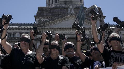 Photojournalists raise their cameras as a protest against the closure of Argentine private news agency DYN in Buenos Aires, November 14, 2017 (EITAN ABRAMOVICH/AFP/Getty Images)