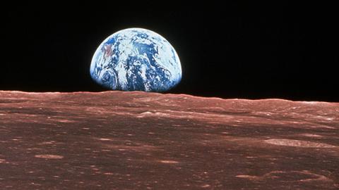 Apollo 11 view of the Earth rising over the surface of the moon 