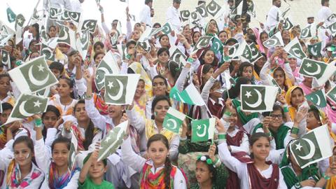 Pakistani girls hold Pakistani flags during a ceremony marking Pakistan's 69th Independence Day, August 14, 2016 