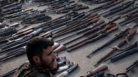 An Syrian Democratic Forces (SDF) fighter looks over seized ISIL weapons that were found in the last stronghold of the extremist group as they were displayed at an SDF base outside Al Mayadin, Syria.