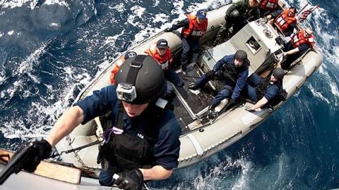 A visit, board, search, and seizure team member from the guided-missile destroyer USS Lassen DDG-82 boards the Republic of Korea navy combat support ship ROKS Chonji AOE-57 with Republic of Korea SEAL/UDT Team members during a joint training mission.