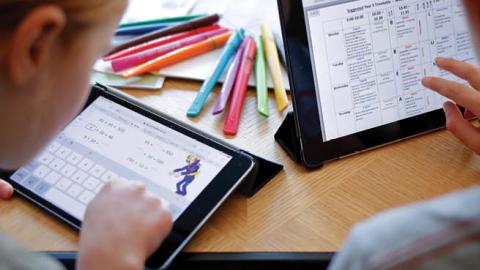 Children use electronic tablets to complete online schoolwork at home. (Getty Images)