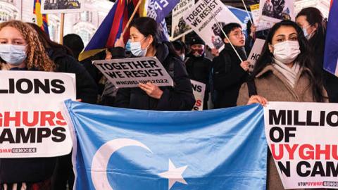 Protesters hold the Uyghur flag and placards that say "Millions of Uyghurs in Camps" during a protest in London, United Kingdom, on December 10, 2021. (Getty Images)