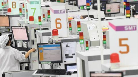 People work on the equipment for surface mount technology (SMT) at an assembly plant in Wuhan, China, on Friday, August 20, 2021. (Getty Images)