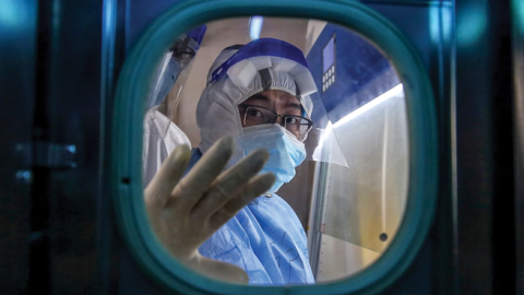  A medical staff member gestures inside an isolation ward at Red Cross Hospital in Wuhan in China's central Hubei province on March 10, 2020. (Photo by STR/AFP via Getty Images)