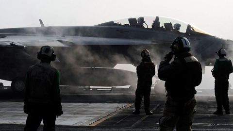 US Navy crew members on deck as a F-18 Super Hornet strike fighter plane takes off from the USS George Washington on the Korean Peninsula's west sea on November 30, 2010 (Song Kyung-Seok - pool/Getty Images)