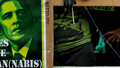 A young woman next to a satirical portrait of U.S. President Barack Obama while marching in support of the legalization of marijuana on August 7, 2010 in Berlin, Germany.(Sean Gallup/Getty Images)